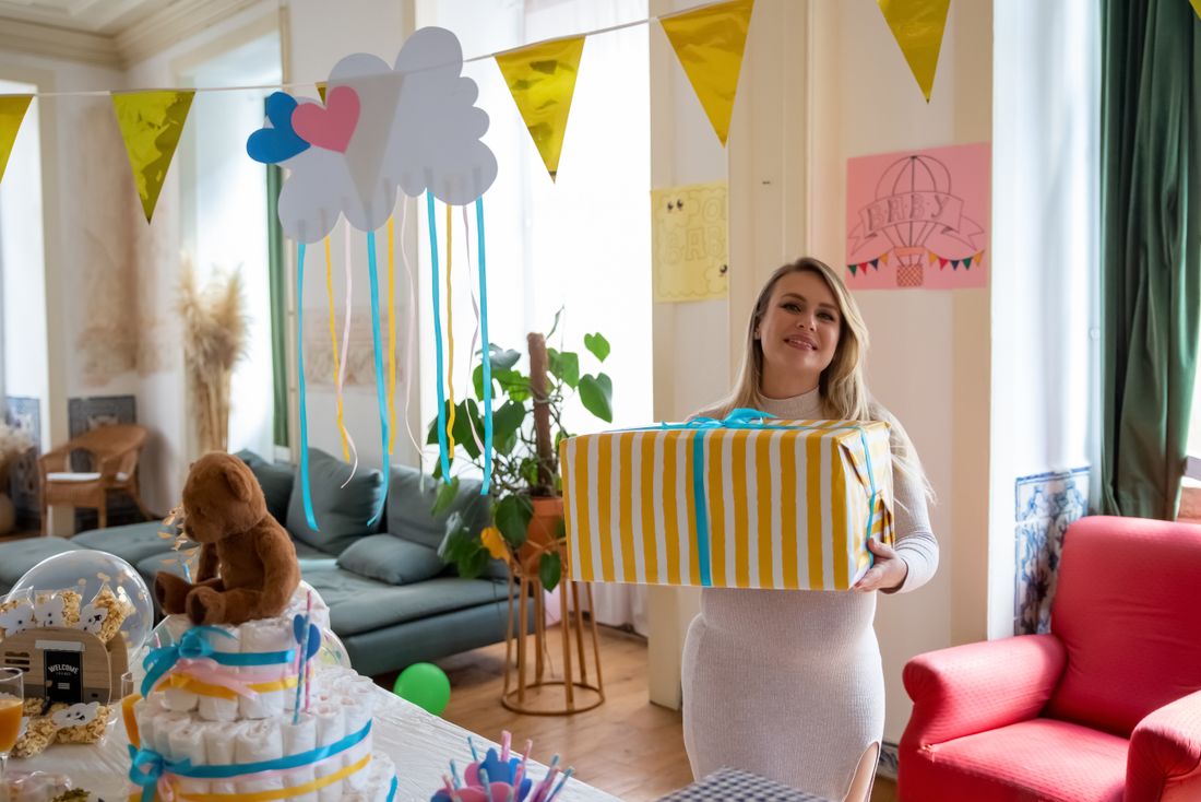 An expectant parent holding a present at a baby shower